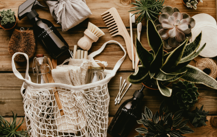 Eco-friendly products in a mesh bag, including reusable bottles and wooden brushes, ideal for a sustainable eCommerce niche.